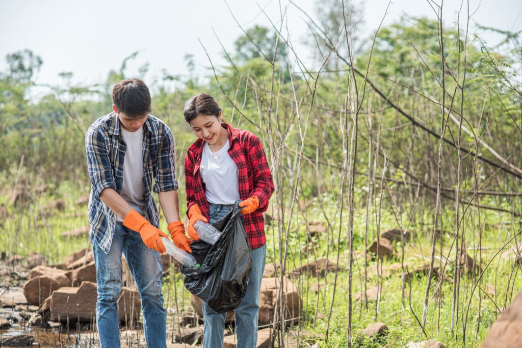men and women help each other to collect garbage.